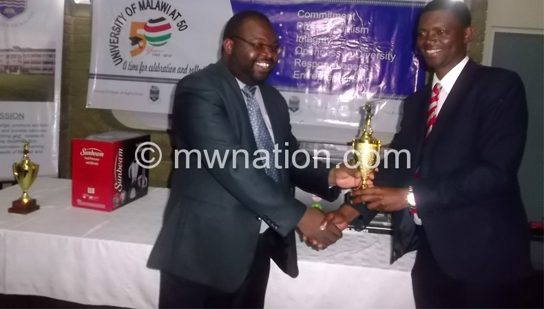 Mwakhwawa (R) receives trophy from Tambulasi