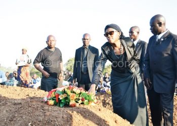 Nyondo’s wife laying a wreath on his grave