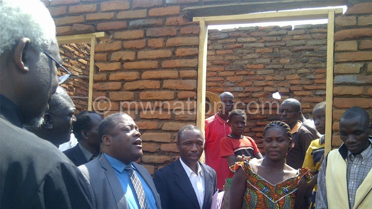 Chibingu(in blue shirt) inspecting one of the buildings in Karonga
