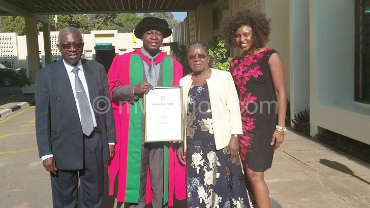 Q shows off his degree flanked by his parents and wife