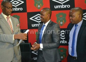 Nyamilandu (2ndR) and Mwenechanya shake hands and show off the sponsorship contract