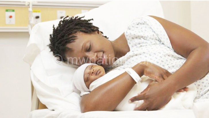 A young woman holds her new-born
