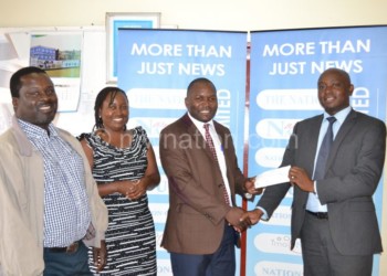 Nhlane (2nd L) receiving the cheque from NBM officials