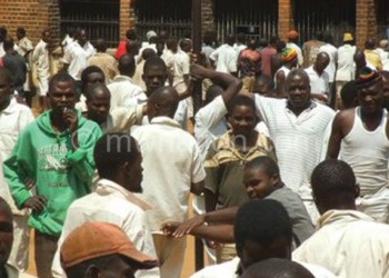 Inmates at Mzuzu Prison queue for their daily meal