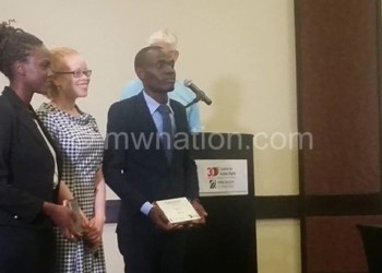 Masanjala (L) and Mchizi (R) pose with a UN represantitive on persons with albinism