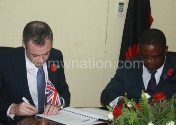 Wharton (L) and Msaka signing the agreement