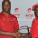 Kachepatsonga (R) receives his prizes from Airtel Malawi managing director Charles Kamoto