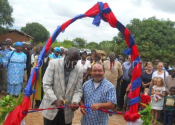 A Zomba District Council official (L) cuts the ribbon to officially open the school