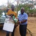 Tony Sekani (R) of Agricultural Trading Company handing over seeds to a farmer