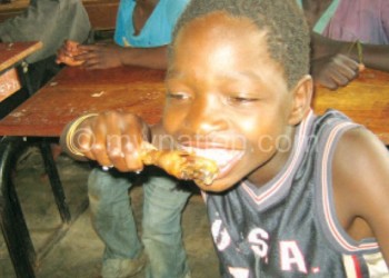 A boy enjoying a chicken at the pre-Christmas party