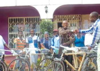 Kumwanje (R) hands over bicycles to Banda