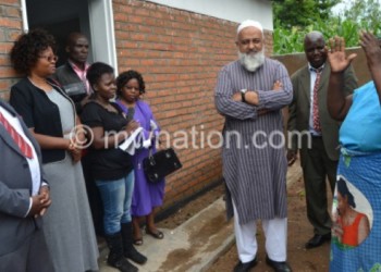 Nthaiya (R), Osman and others outside the house