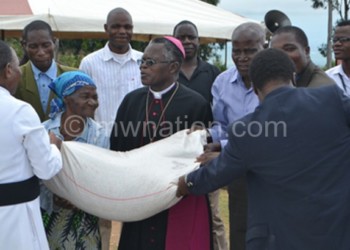 Bishop Musikuwa makes a symbolic presentation of the food items
