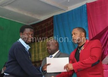 Chilima presenting a certificate to 
one of the students
