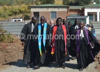 The clergy walk away from the new manse (in background) after 
dedicating it to the Lord