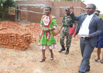 Zalimba (R) takes Chiumia and others around the centre under rehabilitation