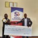 Zimba (R) presents a symbolic 
cheque to Mtumbuka