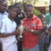 Villa captain Rashid Victor (L) receives a trophy from Kamau