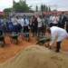 Mhango filling the wheelbarrow with sand