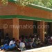 Pupils sit on the veranda of the new classrooms blocks