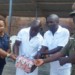 Jana (L) presents Mahewu to to inmates and  Chimodzi in Mzuzu