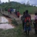 Children cross a makeshift bridge at Mongo