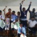 Chess winners celebrate with their trophies as officials look on