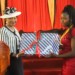 Mutharika (L) hands over a laptop to one of the achievers