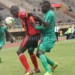Uganda player shields the ball from Malawi's John Banda