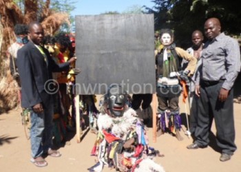 Gule Wamkulu handing over a blacboard to chief Gwirize