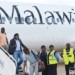 Passengers disembark from Malawi Airlines
