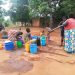 A woman and girls draw water from a borehole