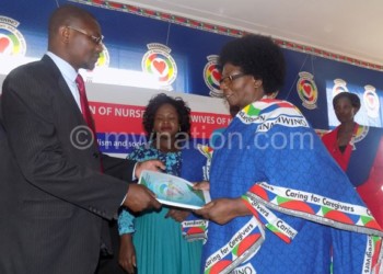 Ngoma (R) hands over a copy of the Nonm constitution to Simeza