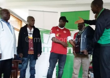 Ngwenya (R) makes a symbolic presentation of the donation to Chigoga (2nd R) as Malunga (L) looks on