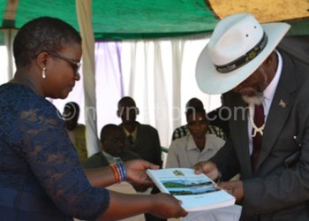 Botoman (L) presents the blueprint to Senior Chief Kapeni