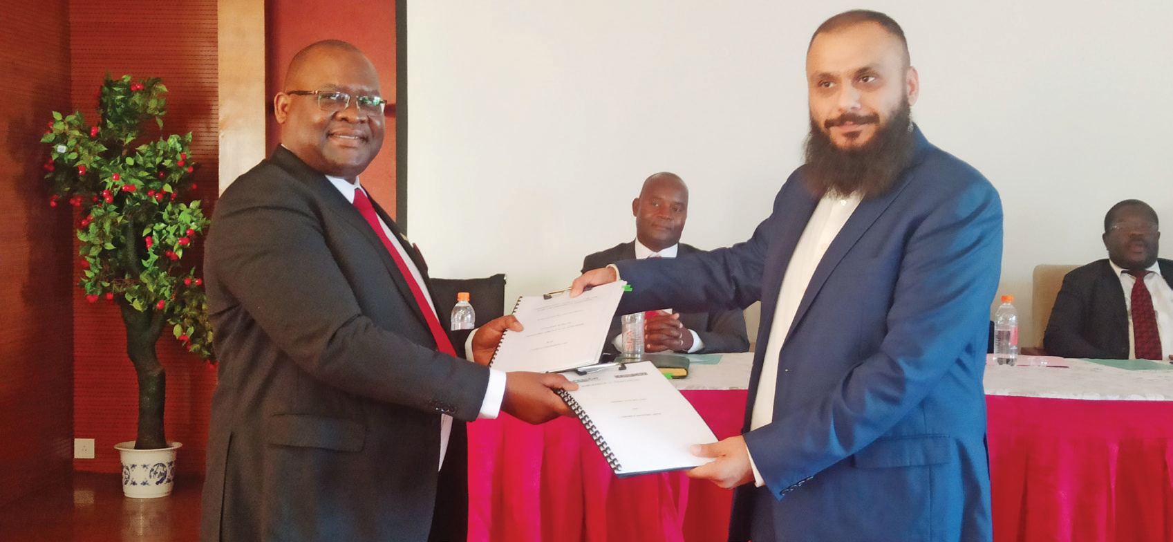 Chidzungu (L) and Suleman exchange MoU documents