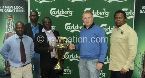 Mcinnes (2nd R) presents the trophy to Chilembwe